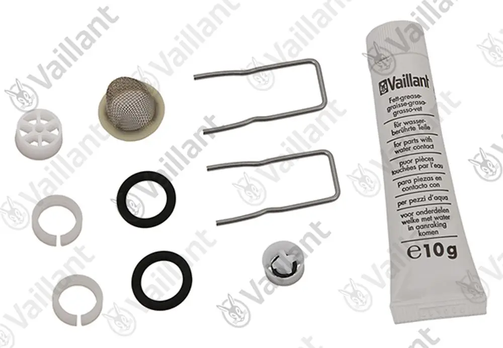 Vaillant Zubehörsatz bestehend aus verschiedenen Dichtungen, Sieben, Halterungen und einer Tube Fett für wasserberührte Teile, angeordnet auf einem weißen Untergrund.